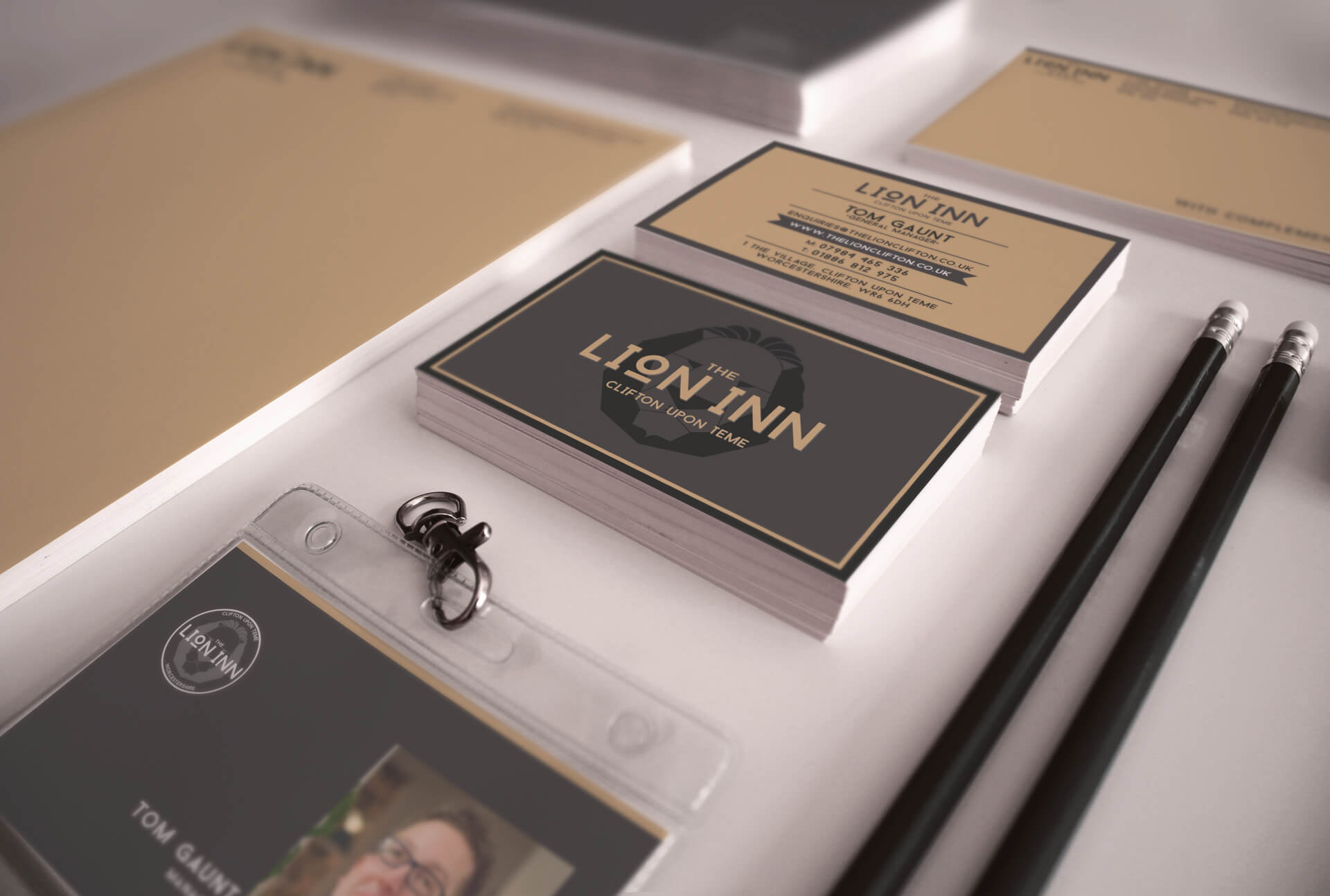 The Lion Inn stationery flatlay — business card, compliments slip or branded paper on warm surface